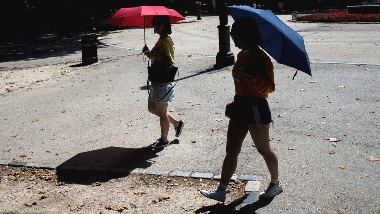 Dos mujeres se protegen del calor con un paraguas