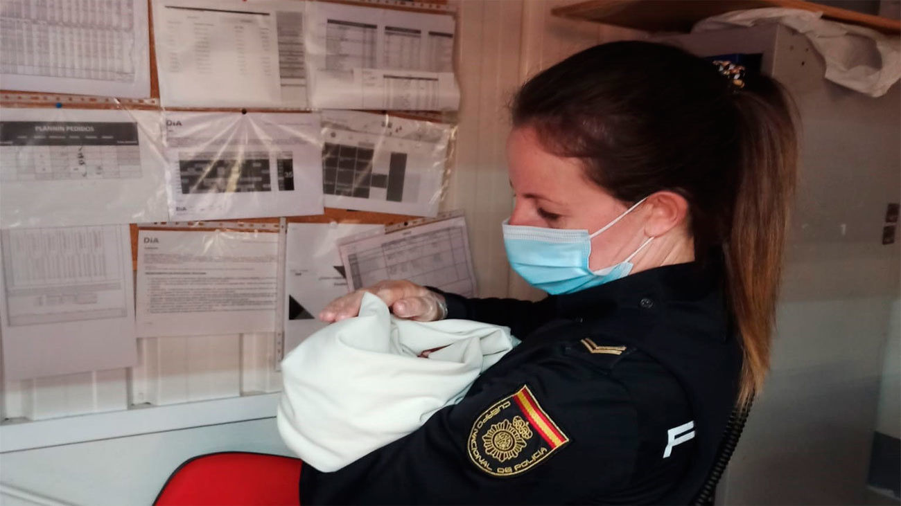El bebé abandonado en un carro de un supermercado en Ávila en brazos de una Policía Nacional