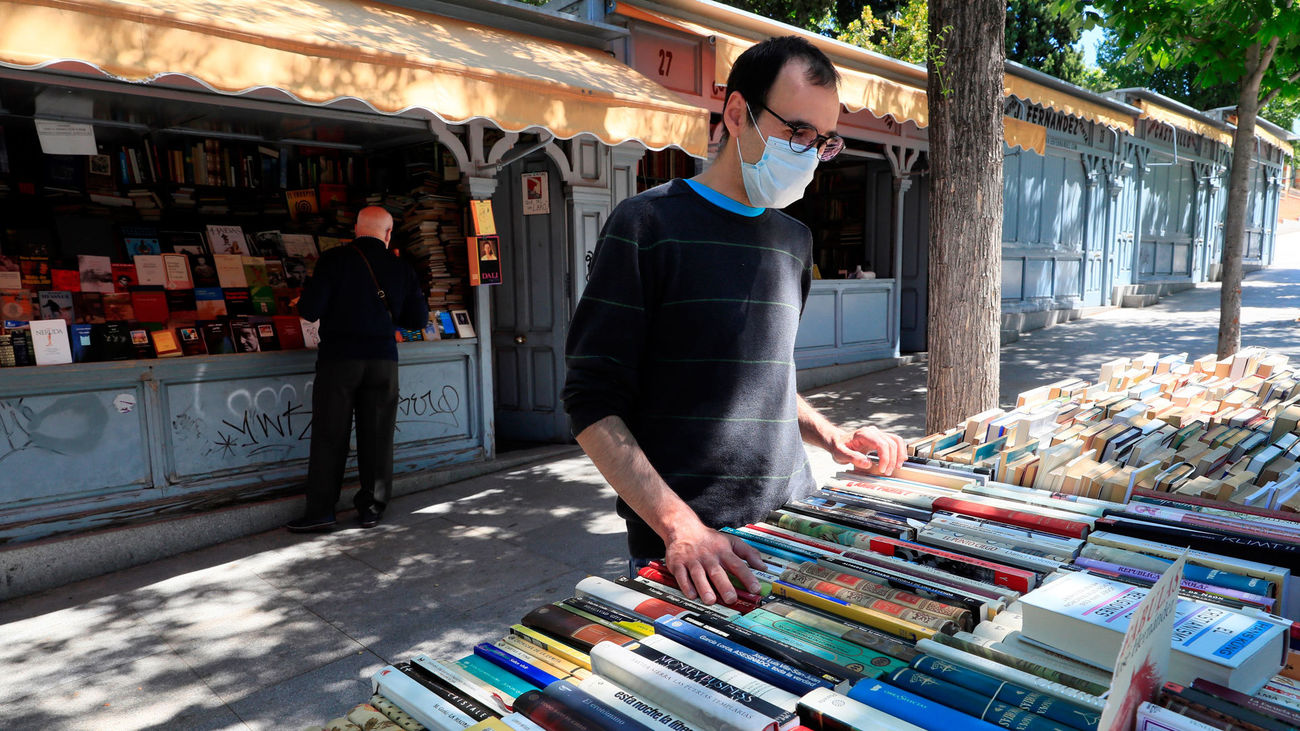 Una persona busca libros en un puesto de la Cuesta de Moyano, reabierto tras el cierre decretado por el covid-19