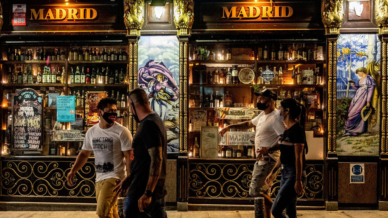 Un grupo de personas pasan frente a uno de los bares de la zona de Huertas y Plaza de Santa Ana en Madrid