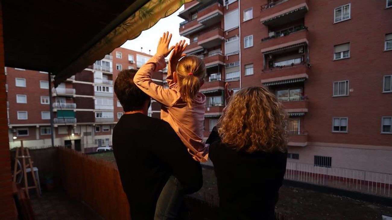 Una familia madrileña se asoma al balcón