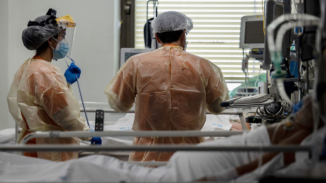 Dos sanitarios atienden a un paciente en la UCI de enfermos de coronavirus en el hospital  Ramón y Cajal