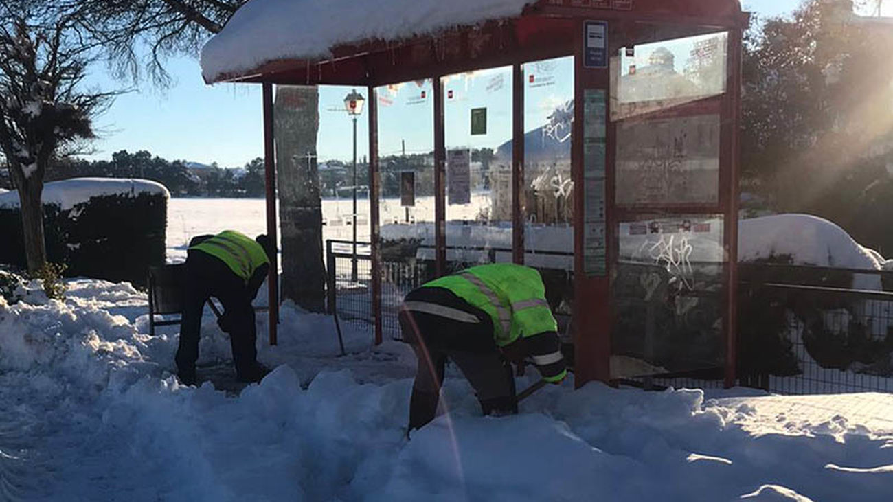 Trabajadores municipales despejan de nieve una marquesina en Nuevo Baztán