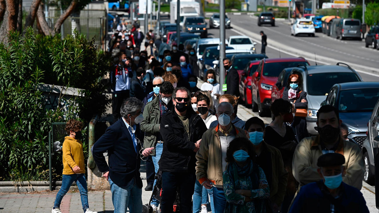 Votantes madrileños esperando a depositar su papeleta en el colegio electoral
