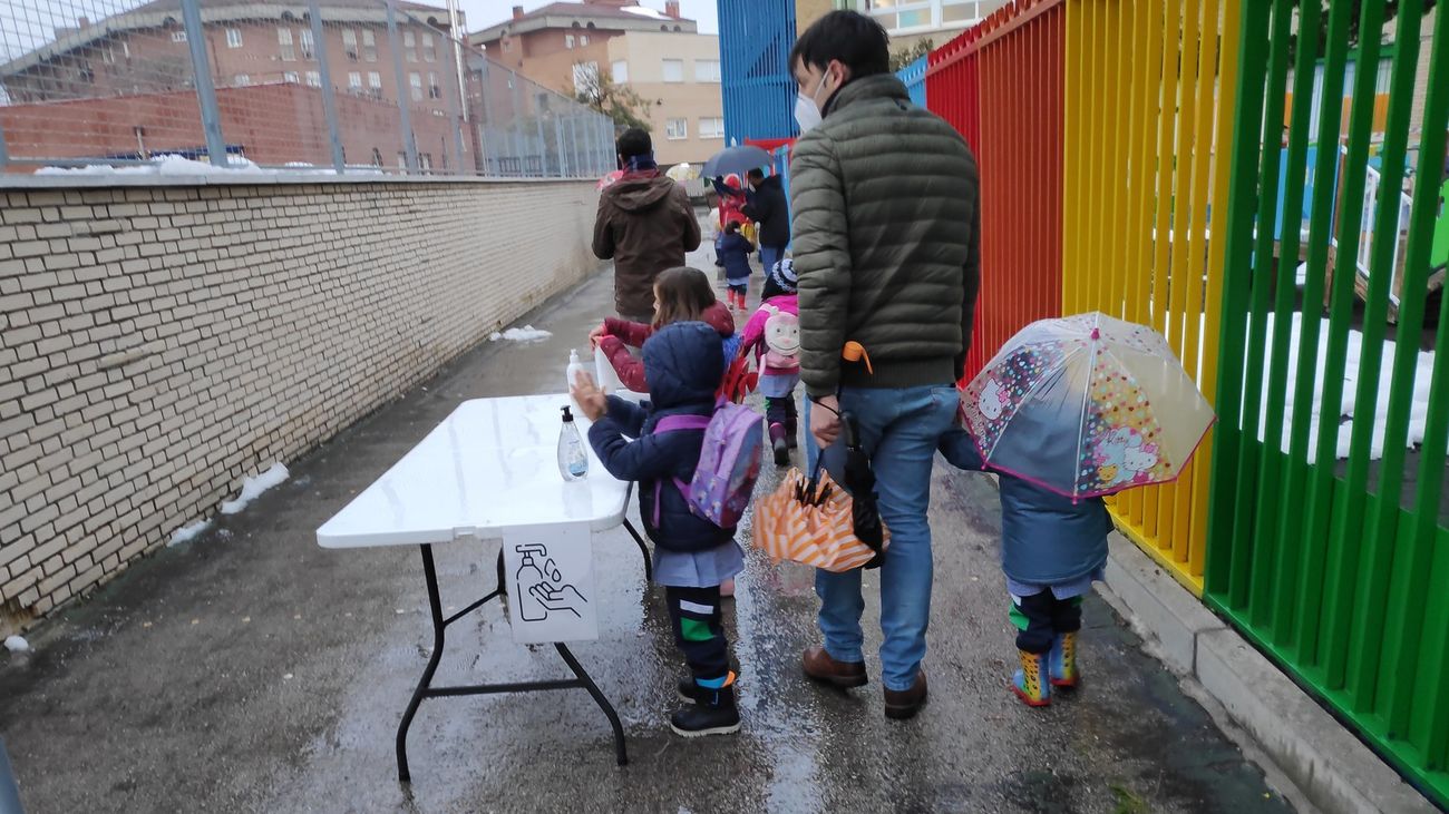 Niños a la entrada de un colegio en mitad de la pandemia y tras la nevada