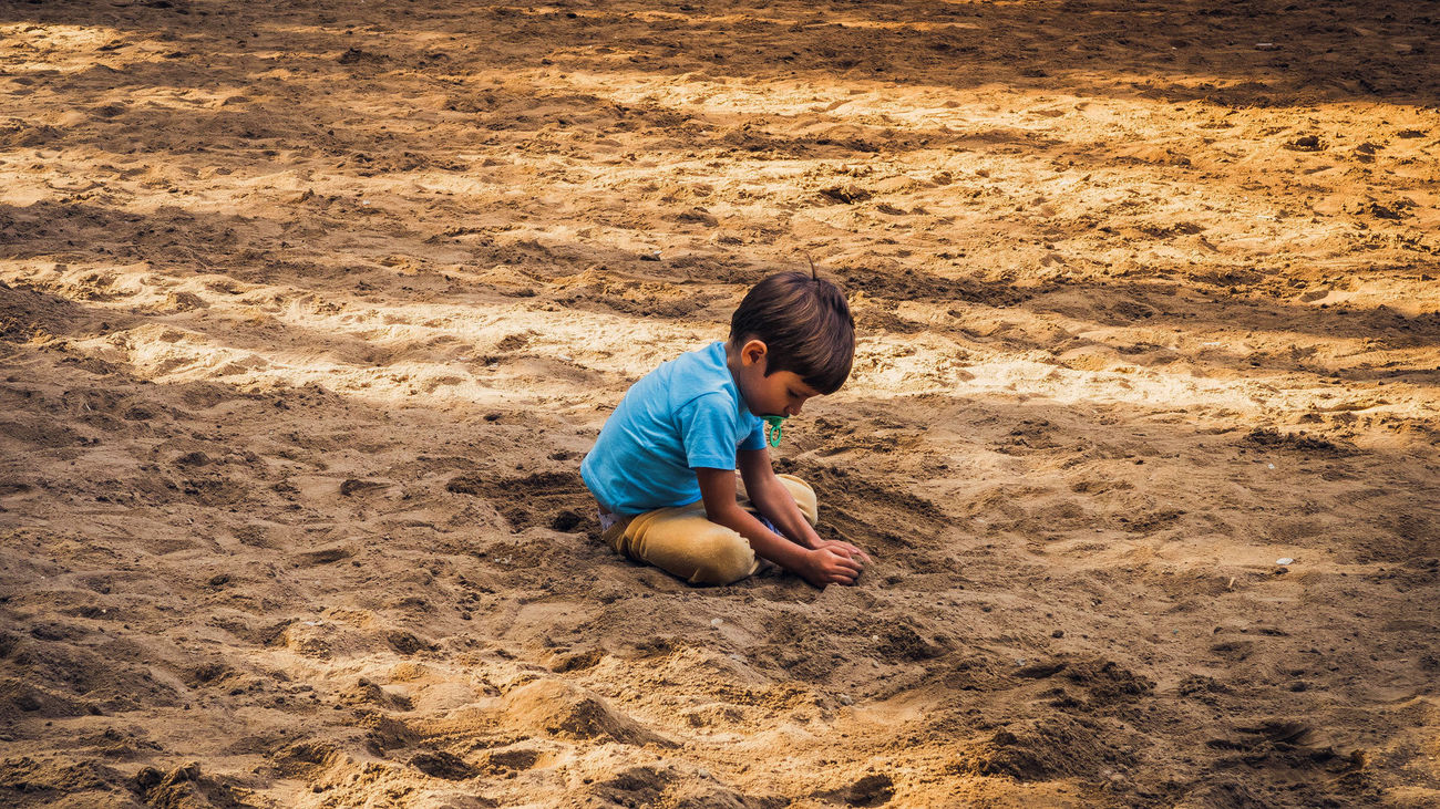 Un niño juega en la arena de un parque