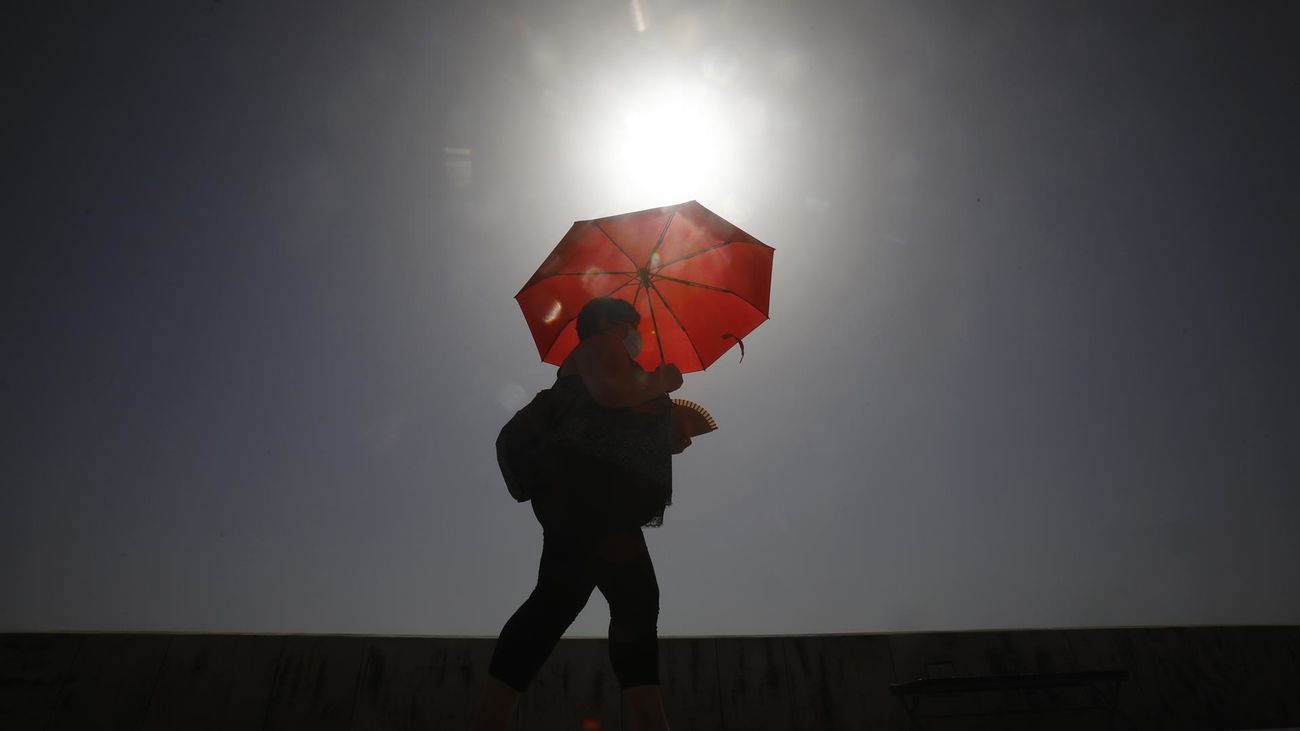 Una mujer se protege del Sol con un paraguas
