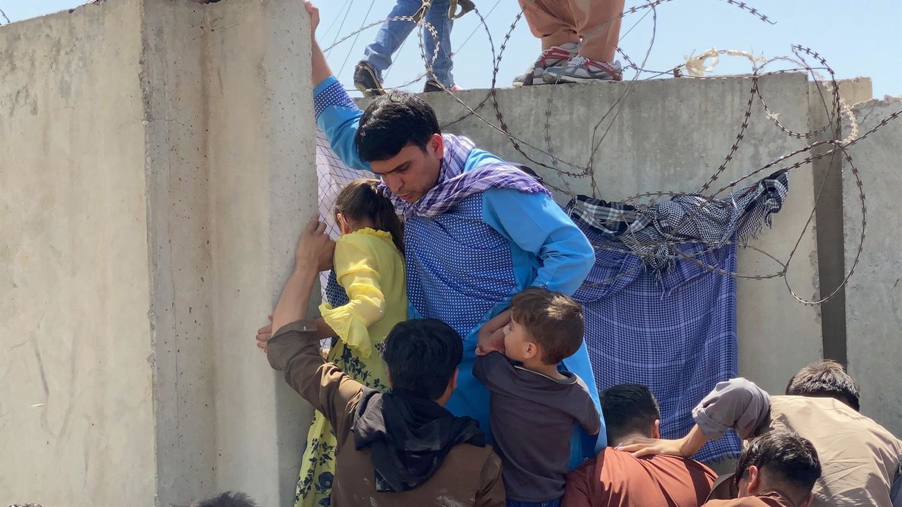 Una familia intenta huir de Afganistán accediendo al aeropuerto