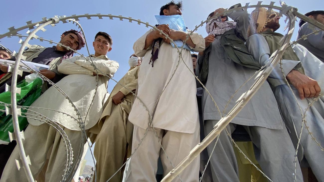 Un grupo de afganos esperan en las afueras del aeropuerto de Kabul para intentar abandonar el país