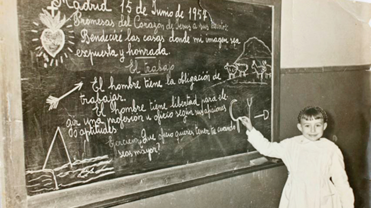 Una niña junto a la pizarra en un colegio de Usera, en 1957