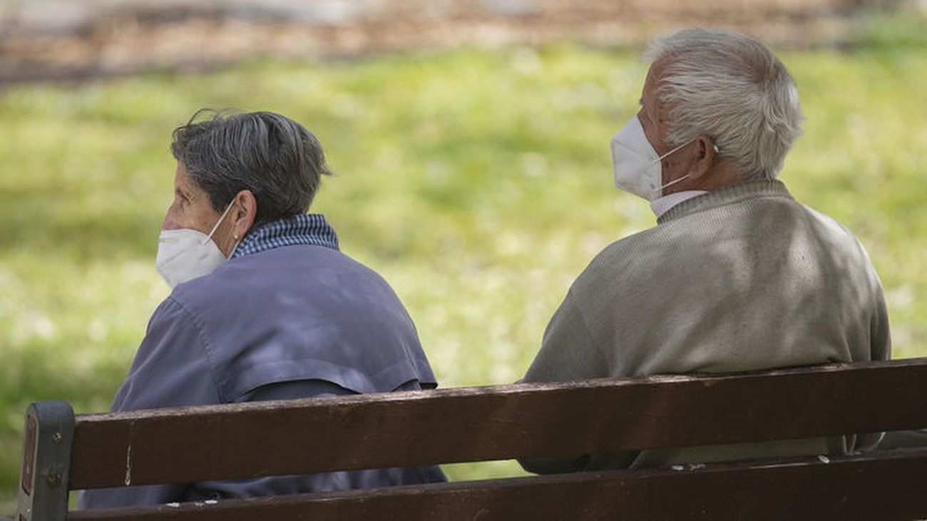Dos personas mayores sentadas en un parque de Madrid