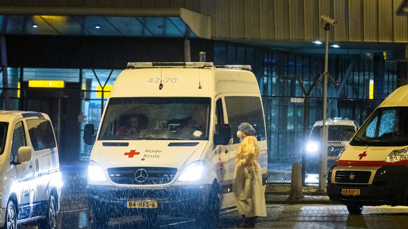 Trabajadores sanitarios de la Cruz Roja trasladan a los pasajeros infectados