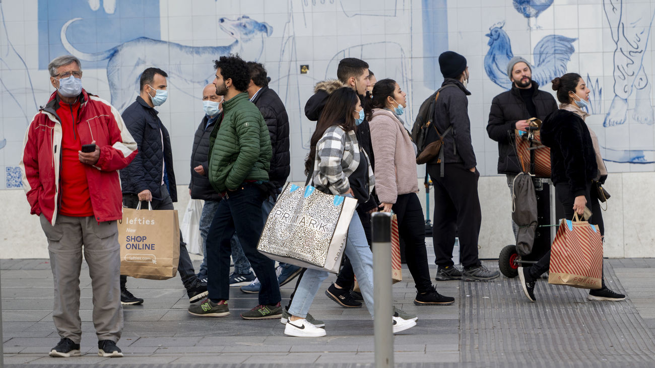 Varias personas caminan con bolsas con compras en Madrid