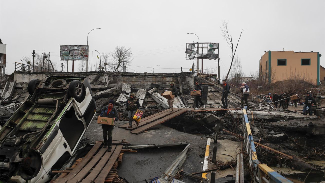 Ucranianos cruzan un puente destruido a la entrada de la ciudad de Irpin