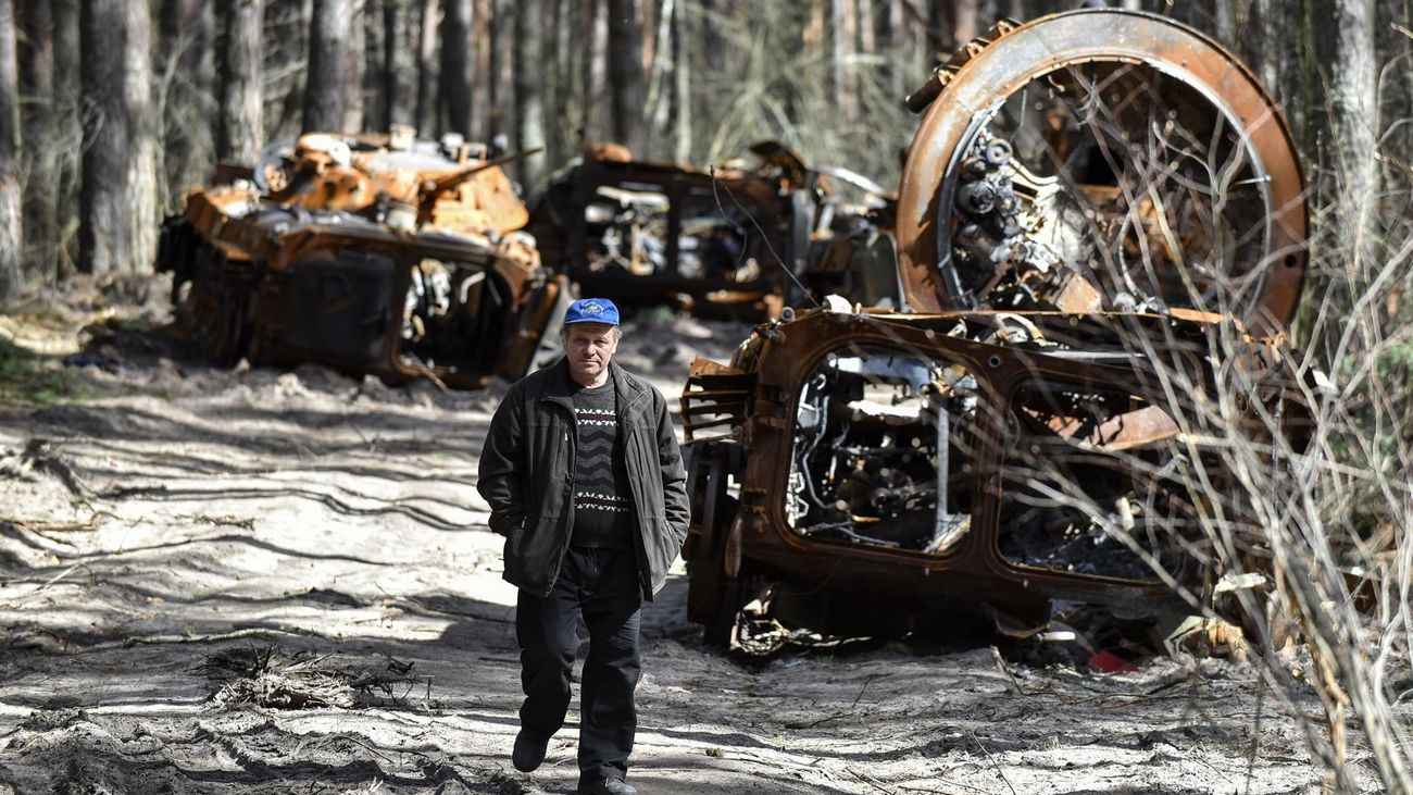 Un hombre camina cerca de los resstos de un convoy ruso destruido en un bosque cerca Kyiv