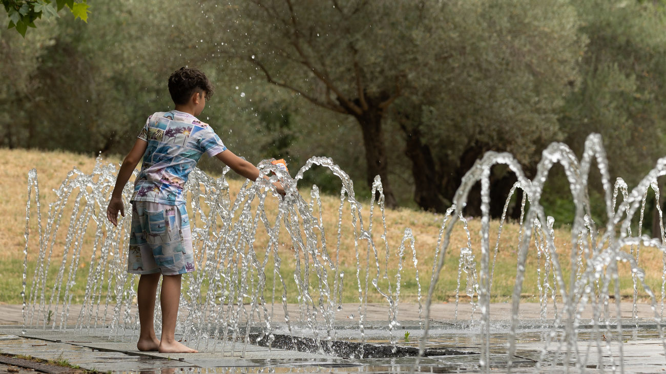 Un niño se refresca en la zona de chorros de agua de Madrid Río