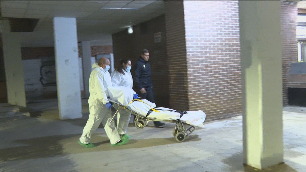 Sanitarios trasladan un cuerpo tras el doble asesinato de una mujer y su hija en Móstoles