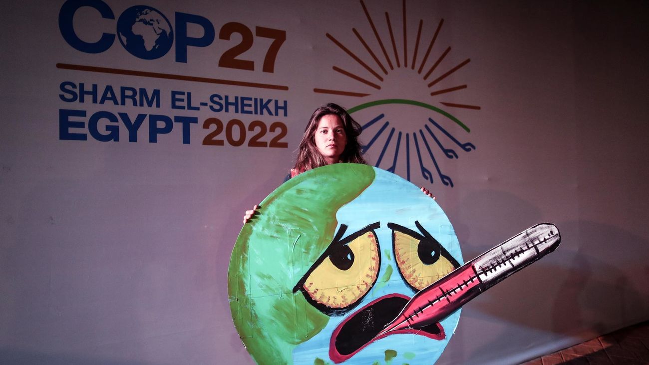 Una activista exhibe un cartel sobre el calentamiento de la Tierra en la COP27 de Egipto