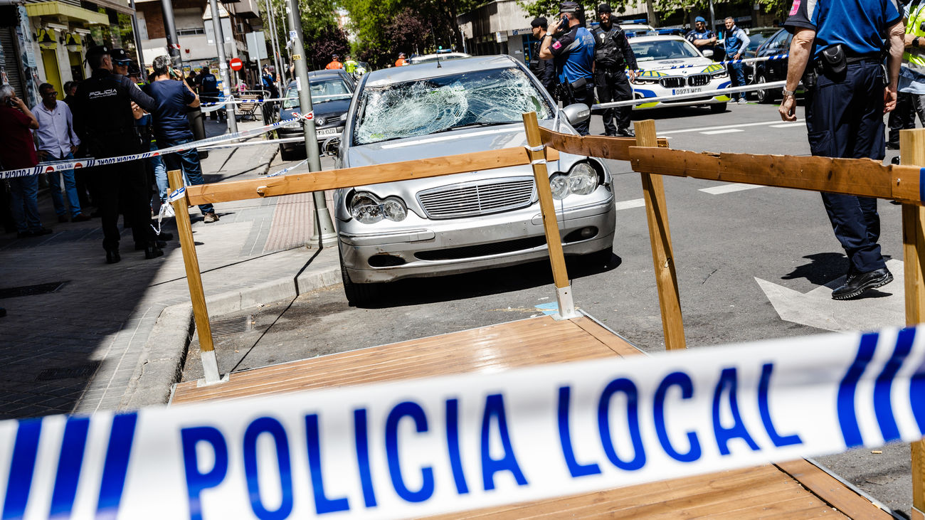 Agentes de la policía nacional custodian el coche con el que han sido atropelladas varias personas en el Paseo de Extremadura