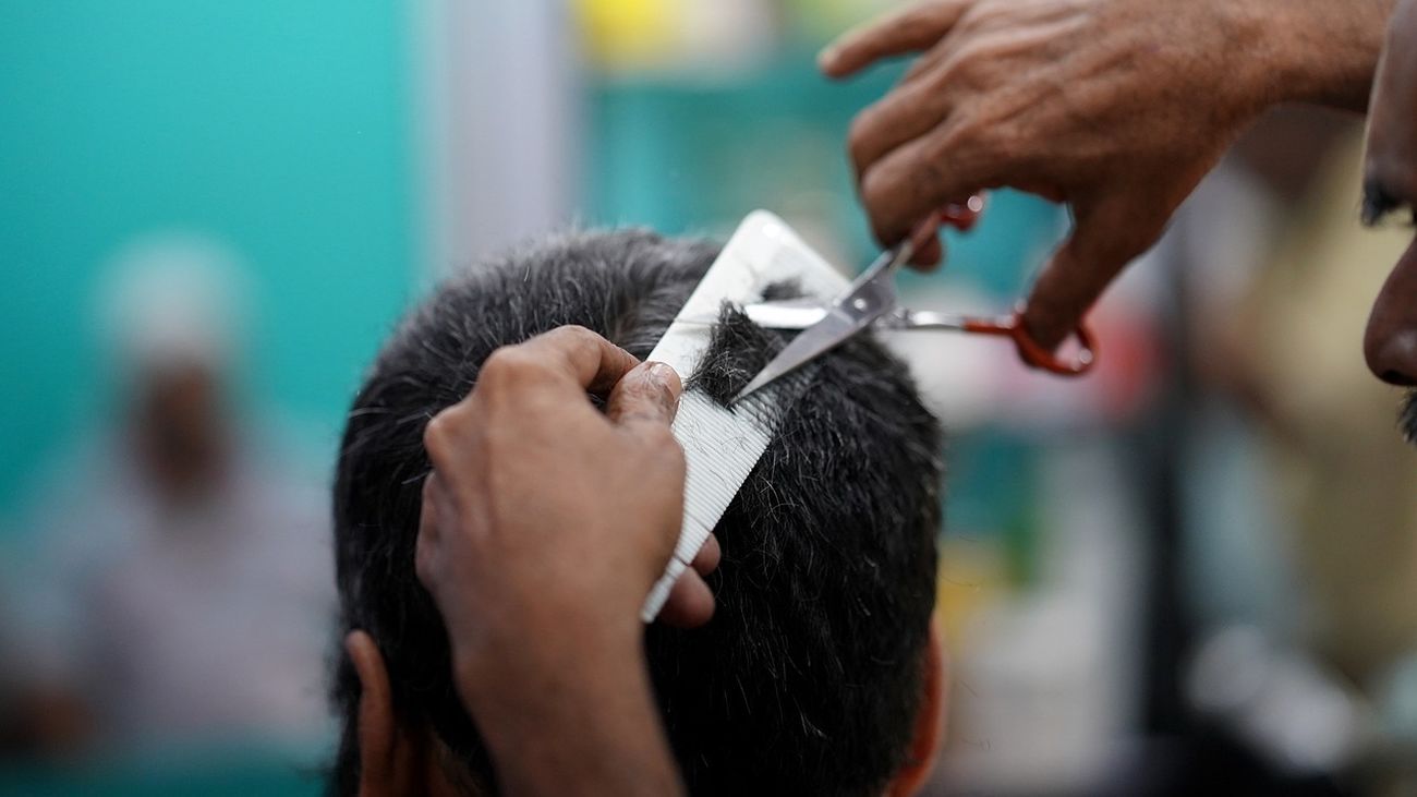 Foto de archivo peluquero cortando el pelo