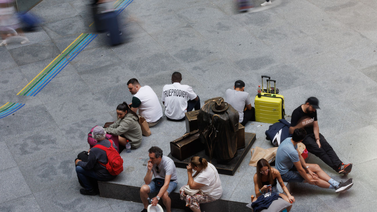 Varias personas esperan con maletas en la estación de Atocha-Almudena Grandes