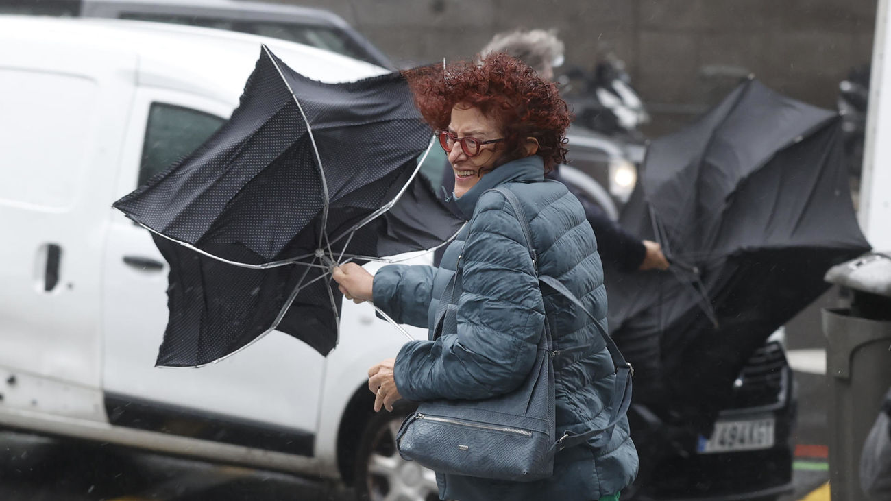 Una viandante se enfrenta a las fuertes rachas de viento