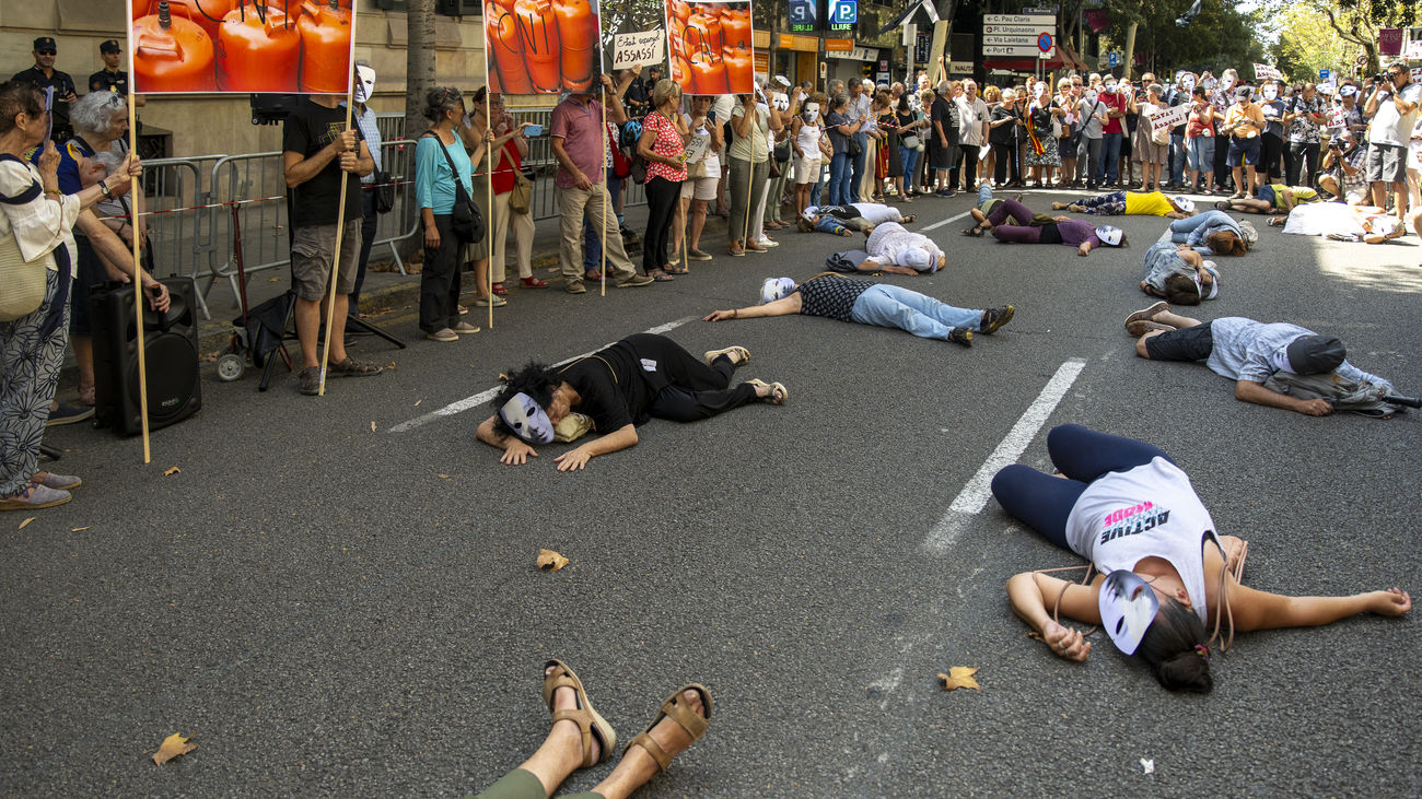 Varias personas se tumban en el suelo como si fueran algunas de las víctimas de los atentados durante una concentración convocada por la plataforma 17A frente a la Delegación de Gobierno, a 17 de agosto de 2023