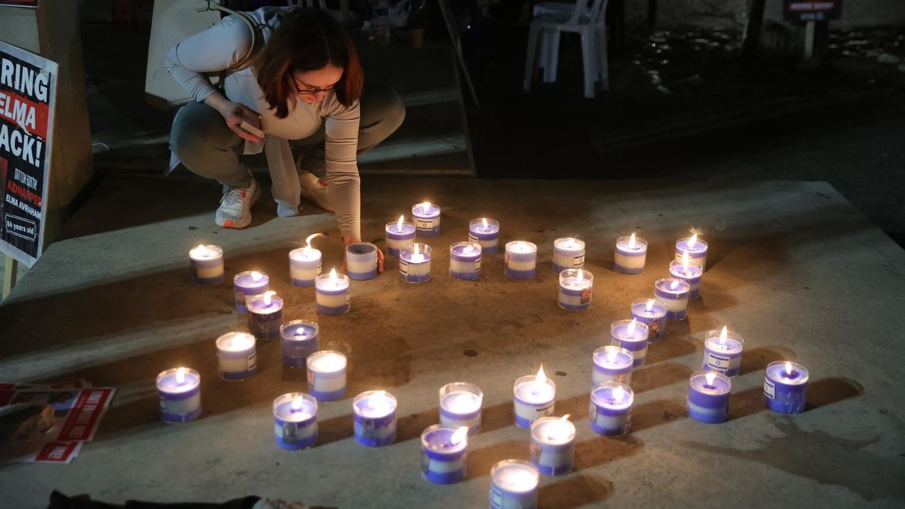 Una mujer enciende velas por la liberación de rehenes en el Museo de Tel Aviv