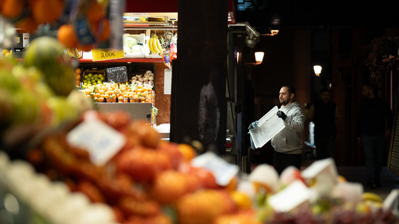 Un comerciante revisa sus productos expuestos, en el Mercado de la Boquería