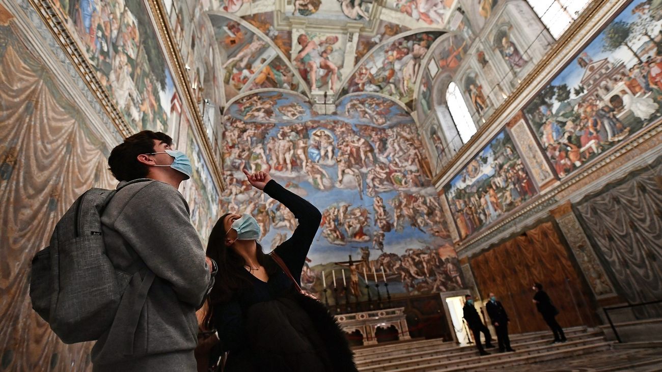 Una pareja contempla los frescos del Día del Juicio Final de la Capilla Sixtina de El Vaticano