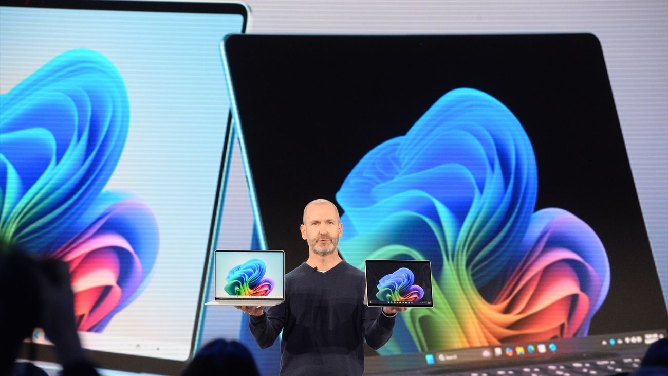 Brett Ostrum muestra un portátil y una tableta de la marca Surface, diseñados para su uso con IA