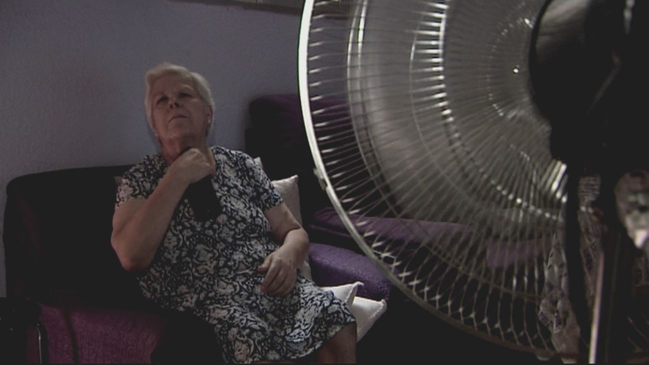 Una mujer se refresca frente a un ventilador