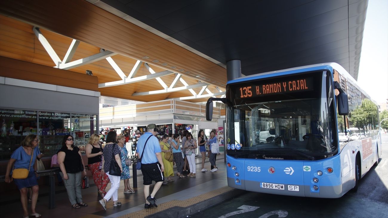 Varias personas esperan al autobús de la EMT, línea 135, en la estación de autobuses de Plaza de Castilla