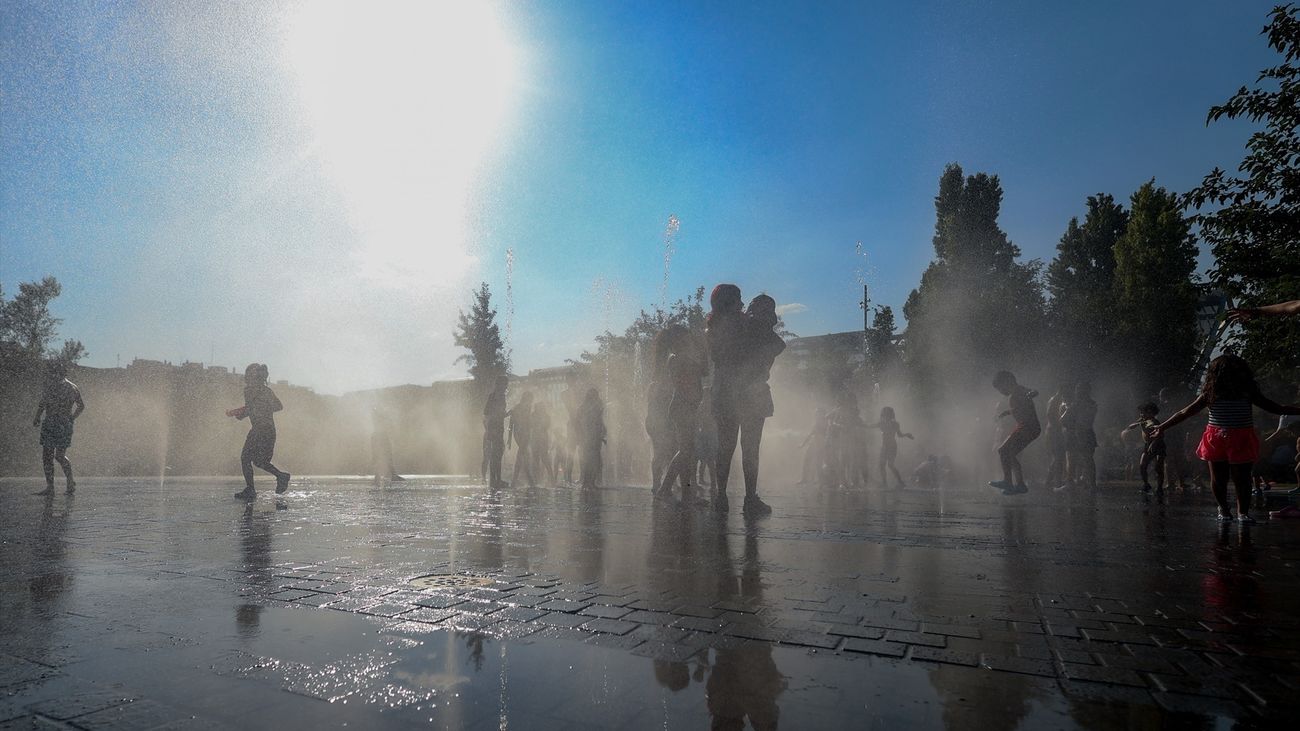 Varios niños se refrescan en una fuente en el parque Madrid Río,