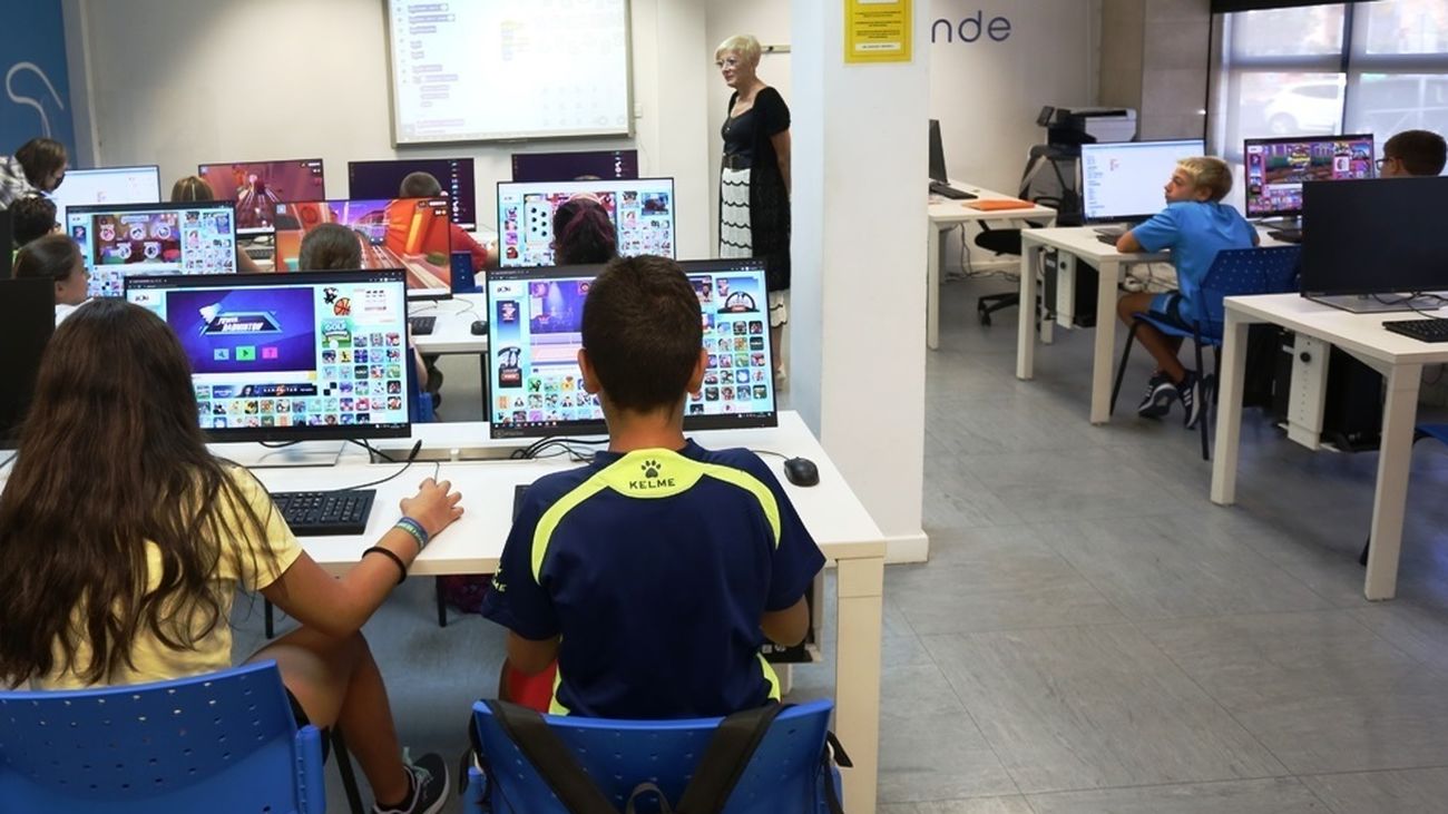 Jóvenes en un aula con equipos informáticos