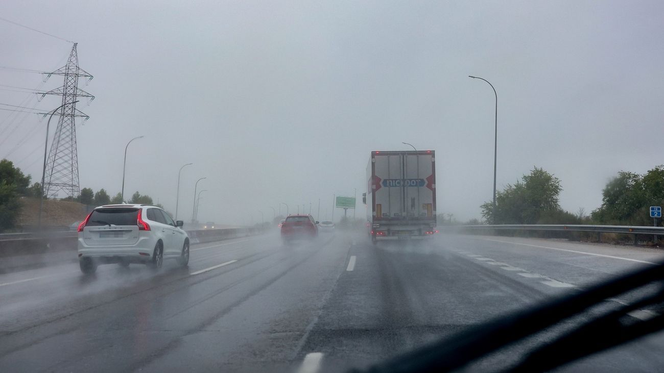 Varios vehículos circulan bajo la lluvia en Madrid