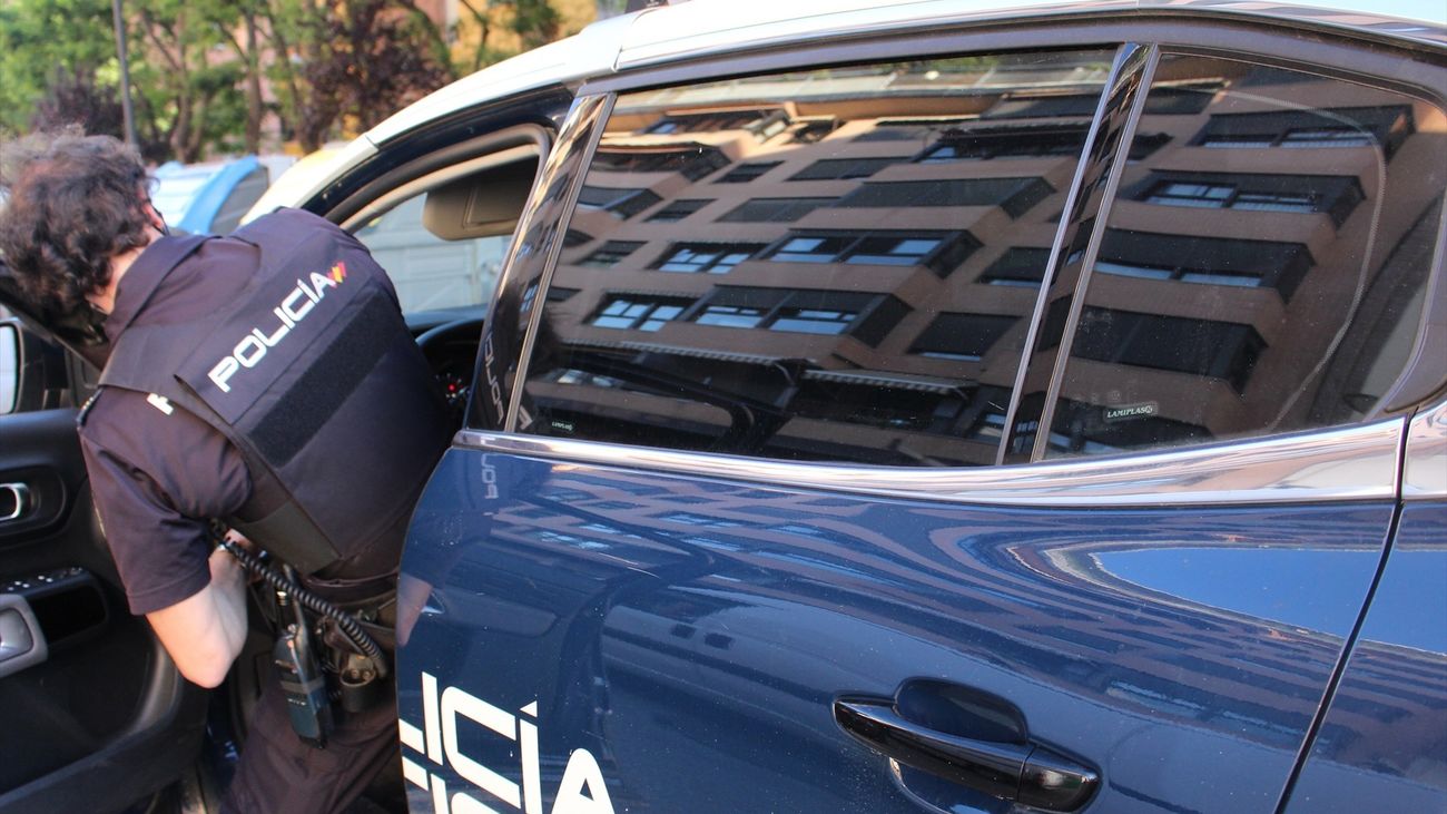 Policia Nacional entrando en el coche patrulla