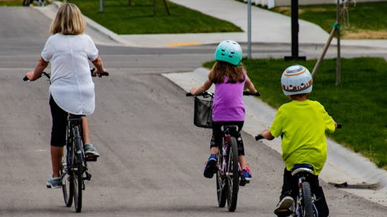 Niños en bicicleta acompañados de un adulto