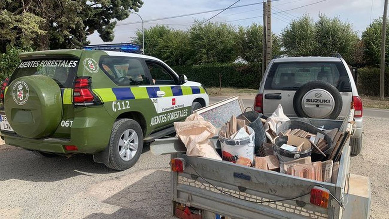 Agentes forestales junto a un vehículo cargado con restos de obra