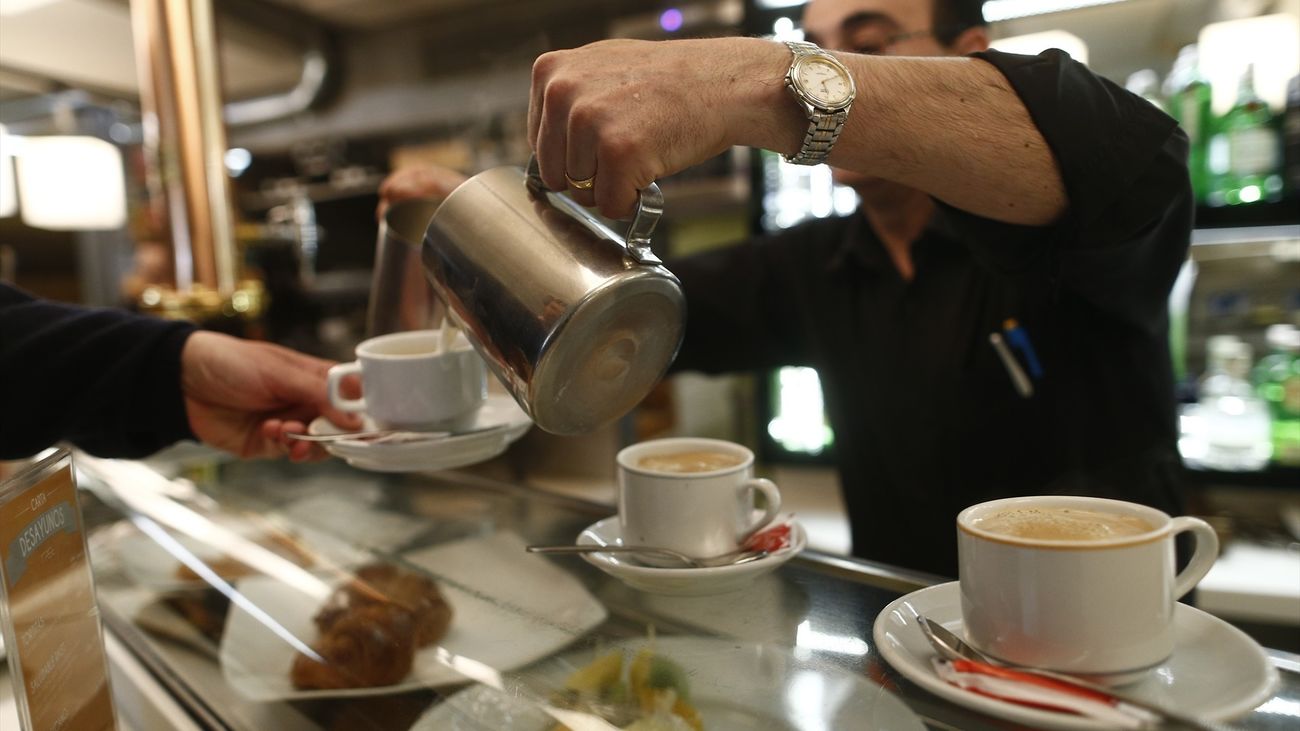 Un camarero sirve cafés con leche