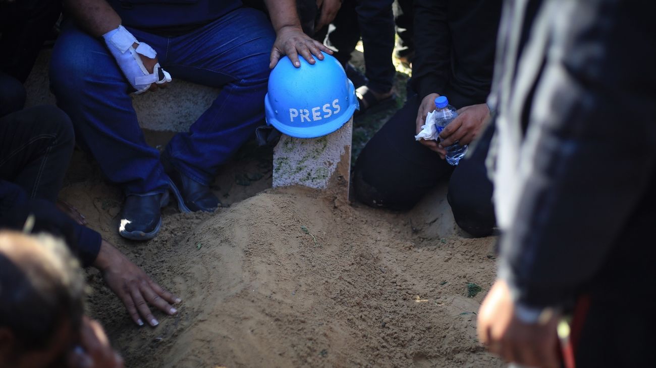 Un casco de prensa se coloca sobre la tumba de un periodista palestino que trabajó para Al Jazeera