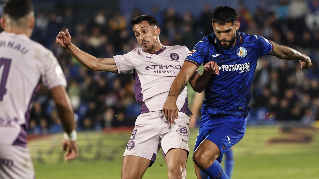 El defensa del Getafe Omar Alderete juega un balón ante Bojan Miovski, del Girona