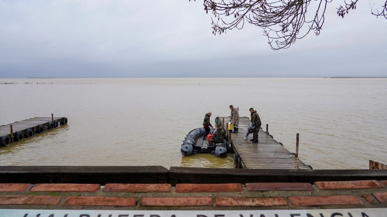 Varios militares de la Armada preparan una lancha para el trabajo de búsqueda en La Albufera