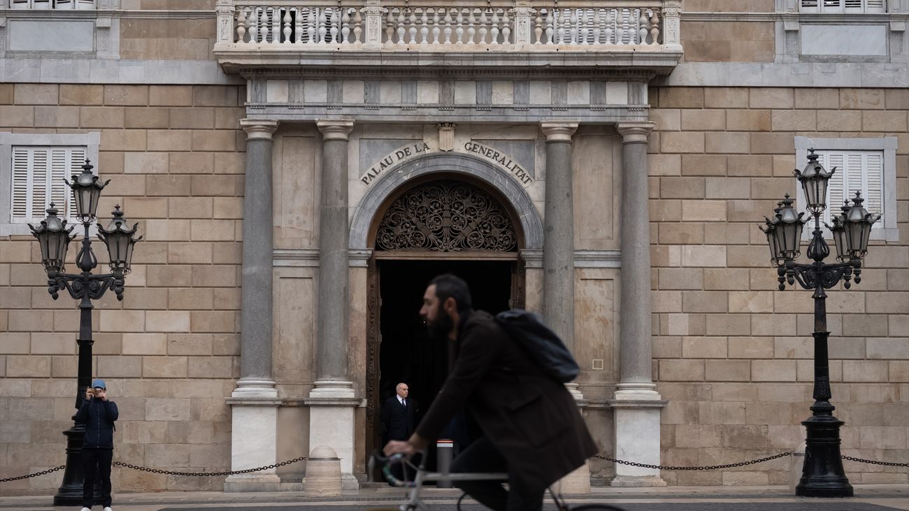 Una persona en bicicleta pasa por delante del Palau de la Generalitat,