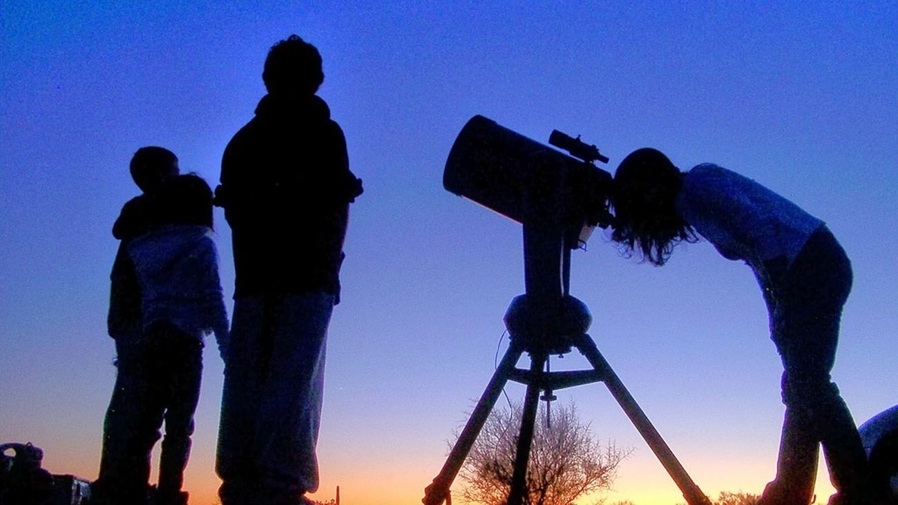 Personas observan el cielo con un telescopio