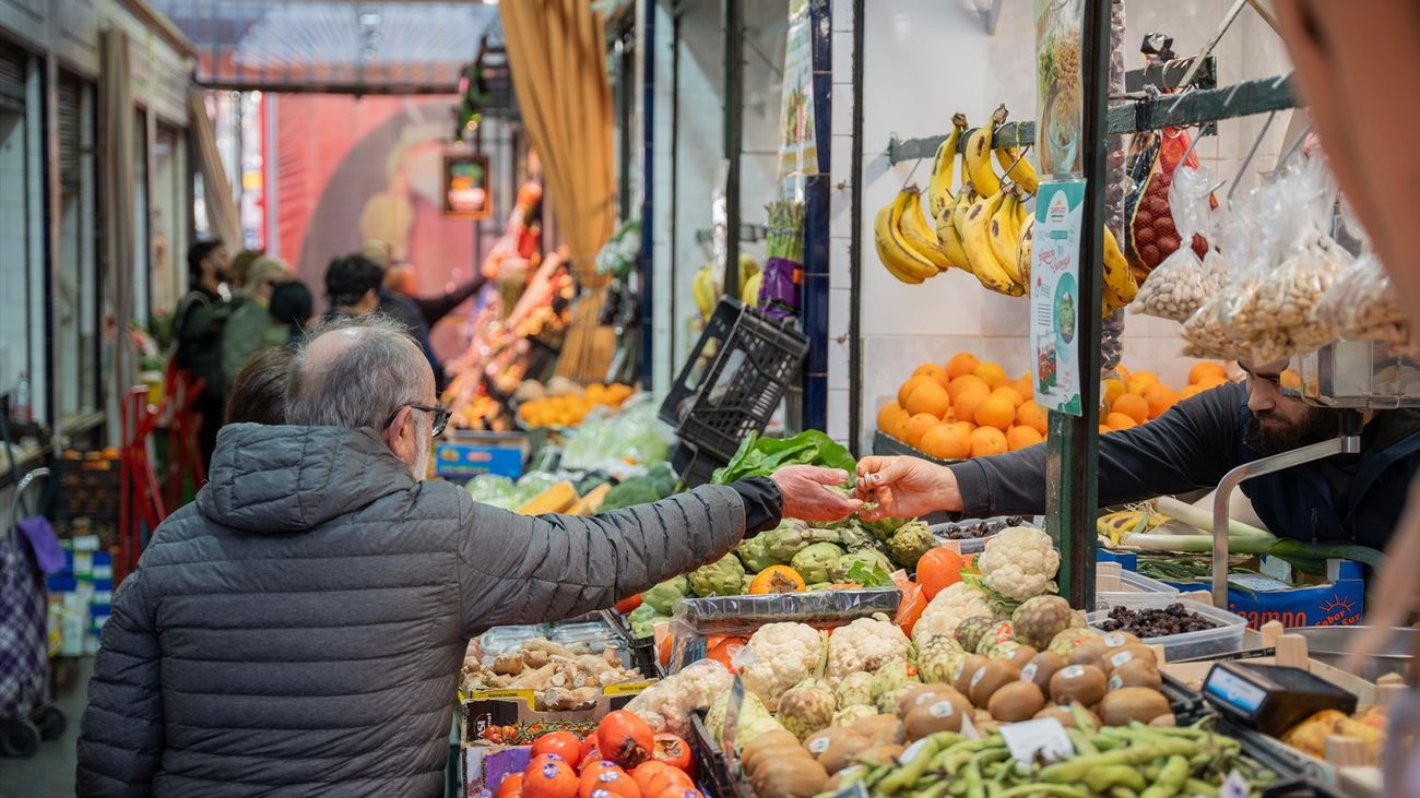 Un hombre en un puesto del mercado de abastos realiza sus compras