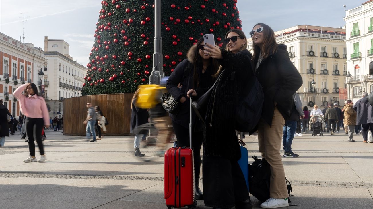 Varias turistas se hacen una foto junto al árbol de Navidad de la Puerta del Sol