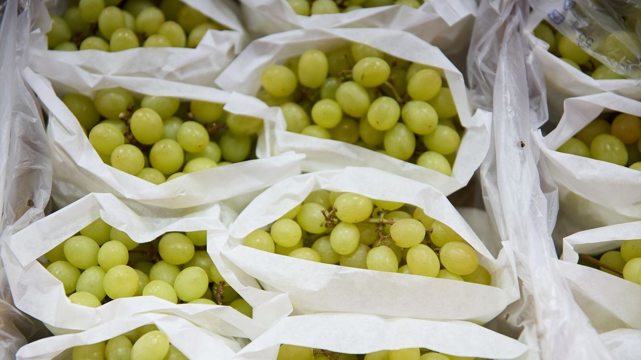 Racimos de uvas en un expositor de una frutería en un mercado