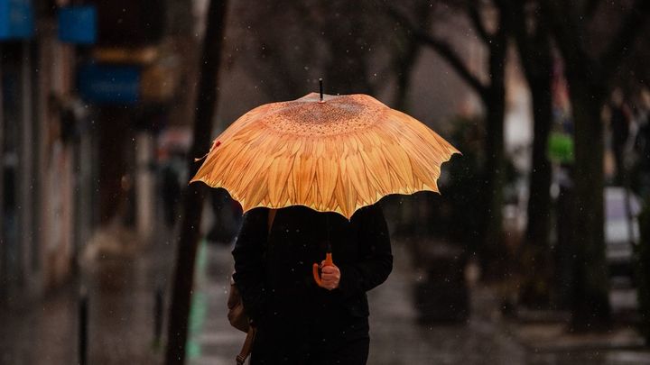 Una persona se protege de la lluvia con paraguas