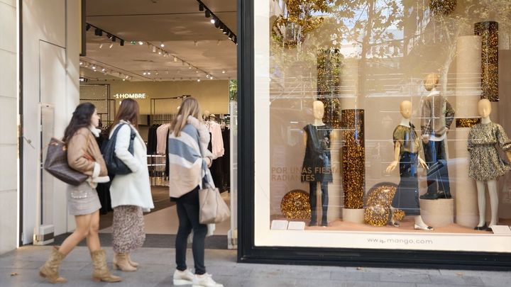 Varias mujer miran la entrada de una tienda,